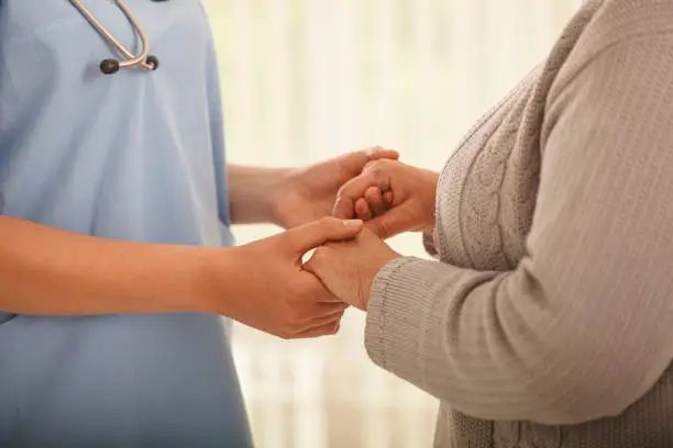 A carer holding a resident's hands