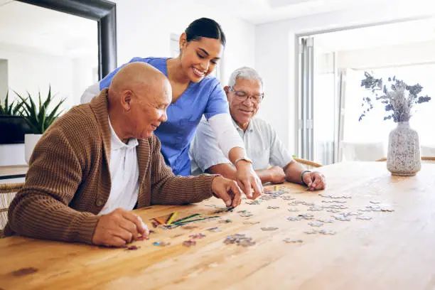 Residents doing a jigsaw puzzle with a carer
