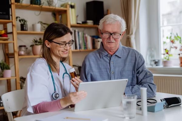 A carer and resident looking at a laptop together