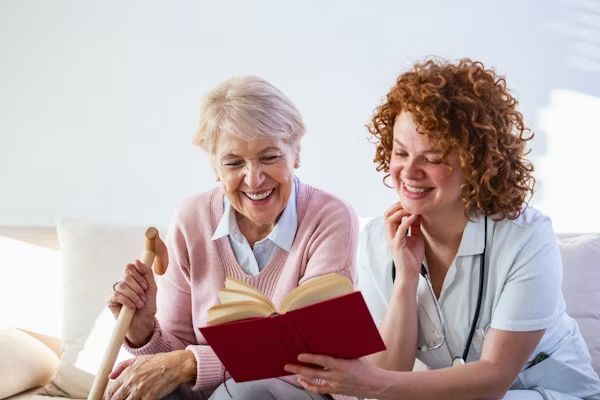 A carer reading a book with a resident